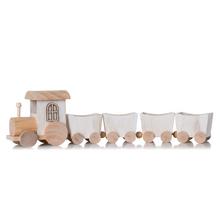 Drevený vianočný vlak so štyrmi vagónikmi v bielej a prírodnej farbe.