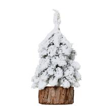 Zasnežený vianočný stromček na pníku.