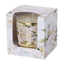 Biela vonná sviečka v skle s kvetinovým dizajnom.