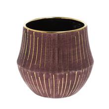 Okrúhly obal burgundskej farby so zlatými pruhmi.