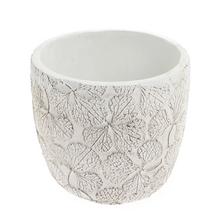 Biely keramický obal na kvety s textúrou listov.