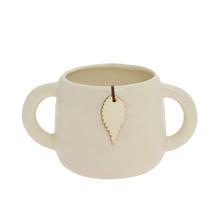 Obal keramika s ušami v krémovej farbe.