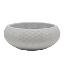 Biely keramický kvetináč s hexagonálnym vzorom.