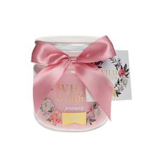 Ružová celoročná sviečka v skle s mašľou.