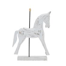 Biely drevený koník s dekoratívnym vzorom.