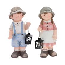 Detská postavička s lampášom v záhrade.