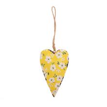 Žlté kovové srdce s kvetinovým vzorom.