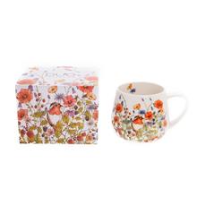 Keramická šálka s lúčnými kvetmi a motýľmi.