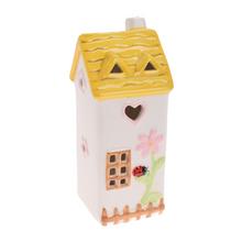 Žltý keramický domček s kvetinovým vzorom.