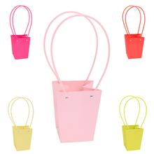 Rôzne farebné tašky na kvety s dlhými uchami.