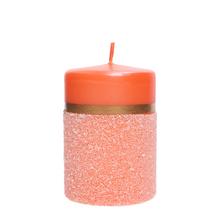 Ružová sviečka s oranžovým vrchom a dekoratívnym pásikom.