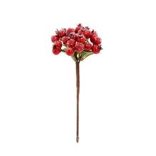 Umelý zápich červených bobúľ so snehom a zelenými listami.