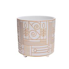 Biely a zlatý kvetináč na nohe s dekoratívnym vzorom.