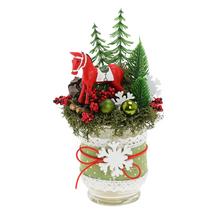 Vianočné aranžmá s červeným koníkom a zelenými stromčekmi.