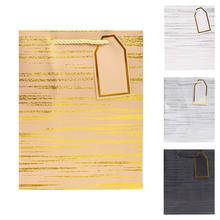 Darčeková taška s pruhovaným vzorom a zlatými detailmi.