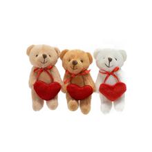 Závesná figúrka medveď v červenom a zelenom oblečení.