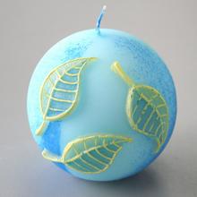 Modrá guľa sviečky s listami.