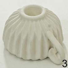 Svietnik v tvare šálky s opakovaným vzorom.