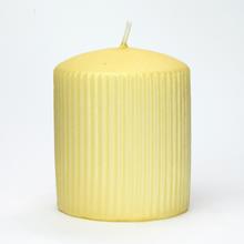 Žltá sviečka s jemným povrchom a vertikálnymi pruhmi.