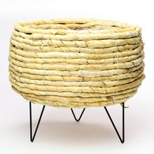 Obal z prírodnej slamy s čiernymi nohami.