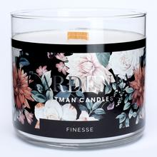 Malá čierna sviečka v skle s kvetinovým dizajnom.