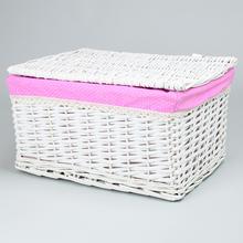 Biely prútený košík s ružovým vankúšom a bodkovaným vzorom.