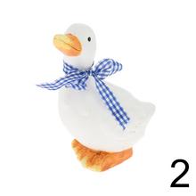 Biela keramická hus s modrou stuhou.