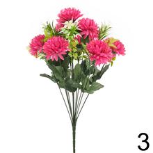 Umelá kytica chryzantémy so zelenými listami.