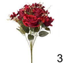 Kytica umelých ruží a papradí v zlatých odtieňoch.