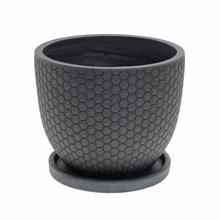 Čierny okrúhly kvetináč s hexagonálnym vzorom.