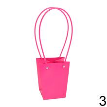 Rôzne farebné tašky na kvety s dlhými uchami.