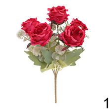 Kytica umelých ruží a eukalyptu v červenej a ružovej farbe.