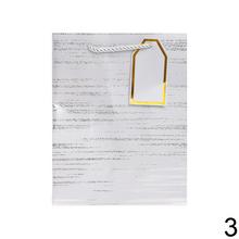 Darčeková taška s pruhovaným vzorom a zlatými detailmi.