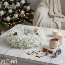 Biely vianočný veniec s kvetinovými detailmi.