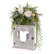 Smútočná väzba s kvetinami v drevenej lucerne srdcového tvaru.