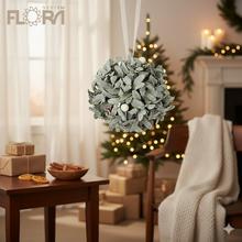 Ozdobná guľa z čečinových listov s bielymi detailmi.