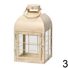 Kovový lampáš v troch farbách: čierny, šedý a biely.