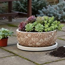 Hnedá a béžová keramická misa s podložkou, zdobená kvetinovým vzorom.