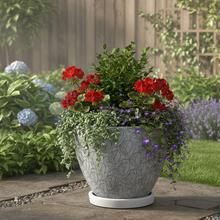 Biely keramický kvetináč s okrúhlou miskou a vzorom listov.