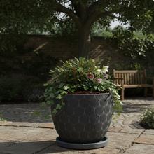 Čierny keramický kvetináč s miskou, okrúhly tvar.