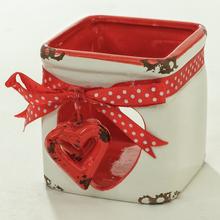 Svietnik mašľa s červenou stuhou a srdiečkom.