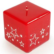 Červená sviečka v tvare kocky so bielymi hviezdami.