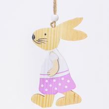 Drevený zajačik v ružovom oblečení, zavesený na šnúrke.