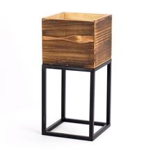 Hnedý obal na kvety s čiernym stojanom.