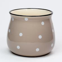 Obal na kvetináč s bodkami v krémovej farbe.