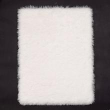 Biela podložka z polyesteru s kožušinovým vzhľadom.