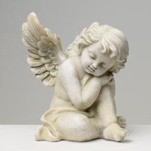 Sivý smútočný anjel s krídlami sediaci na zemi.