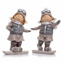 Dve deti na snowboarde v zimných oblekoch.