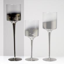 Strieborný svietnik v tvare pohára s vysokým podstavcom.