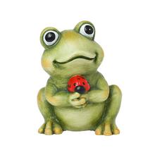 Keramická žaba s lienkou v rukách.